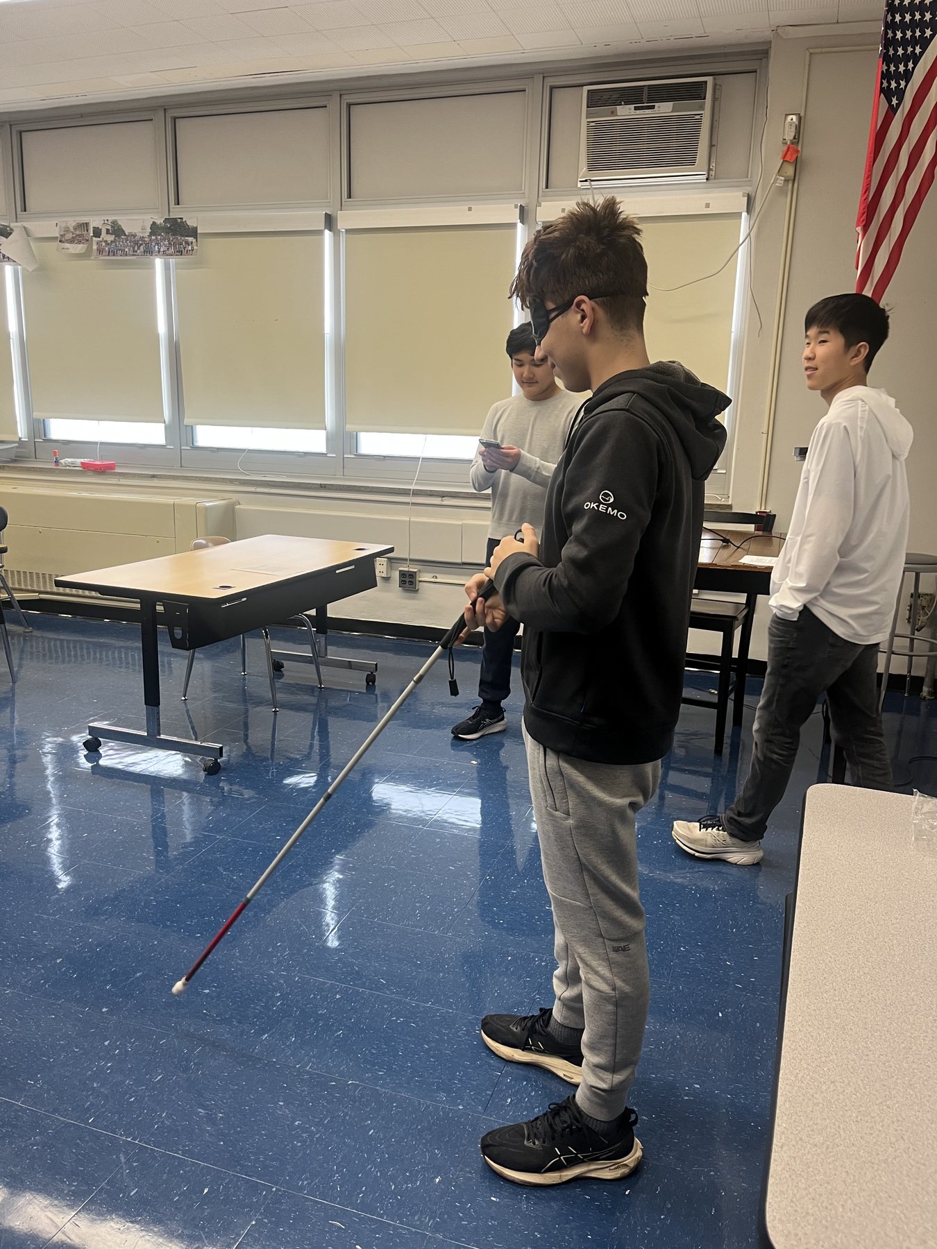 A student holding a white cane during a BridgED activity