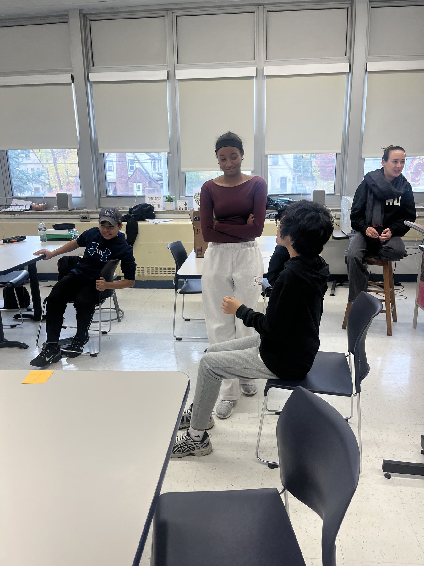 Students and a mentor talking together in a bright classroom